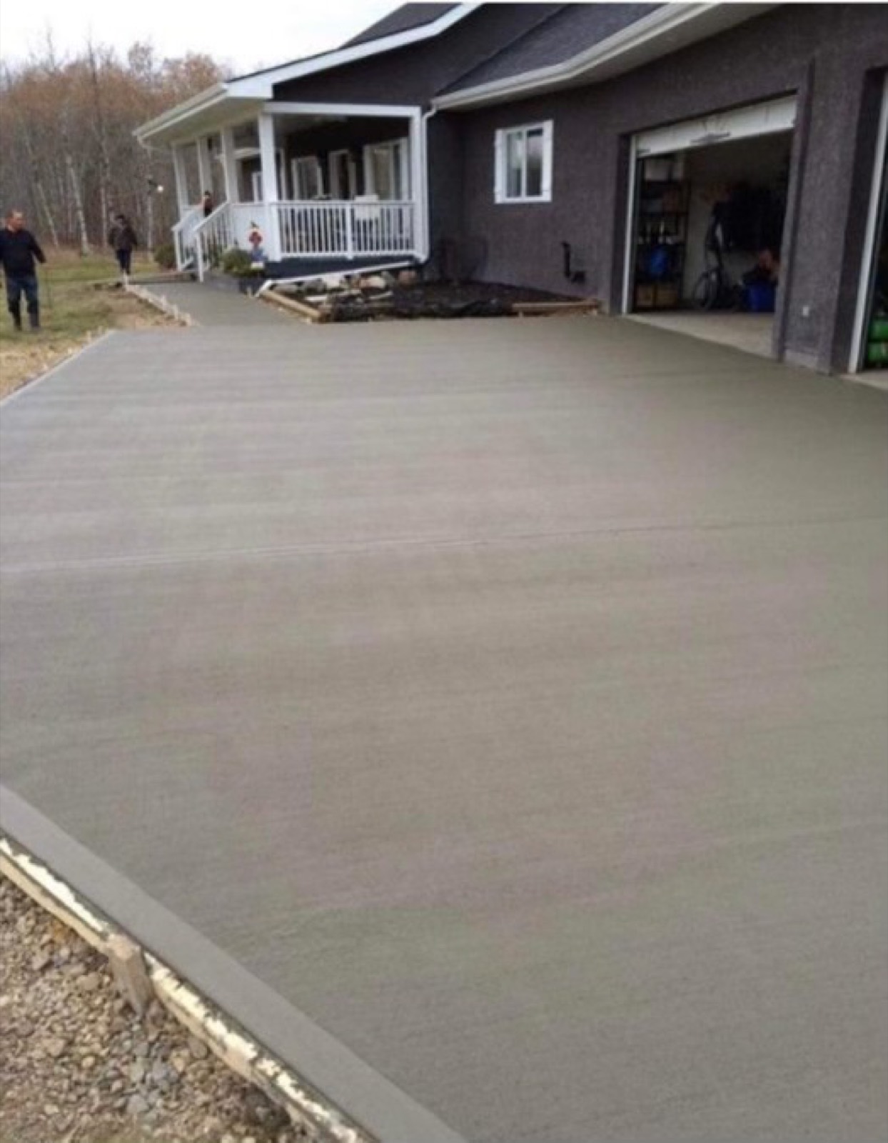 Freshly poured concrete driveway in front of a garage