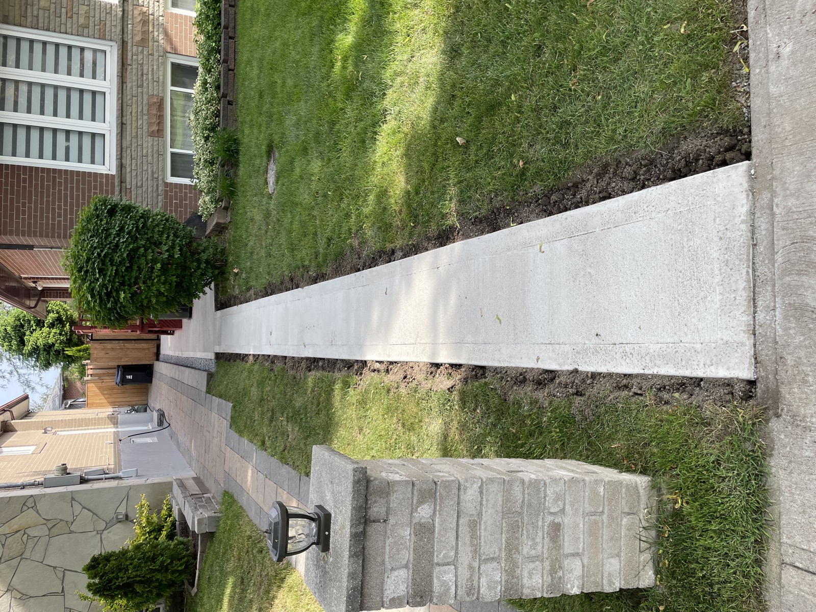 New concrete sidewalk between two houses in a residential neighbourhood