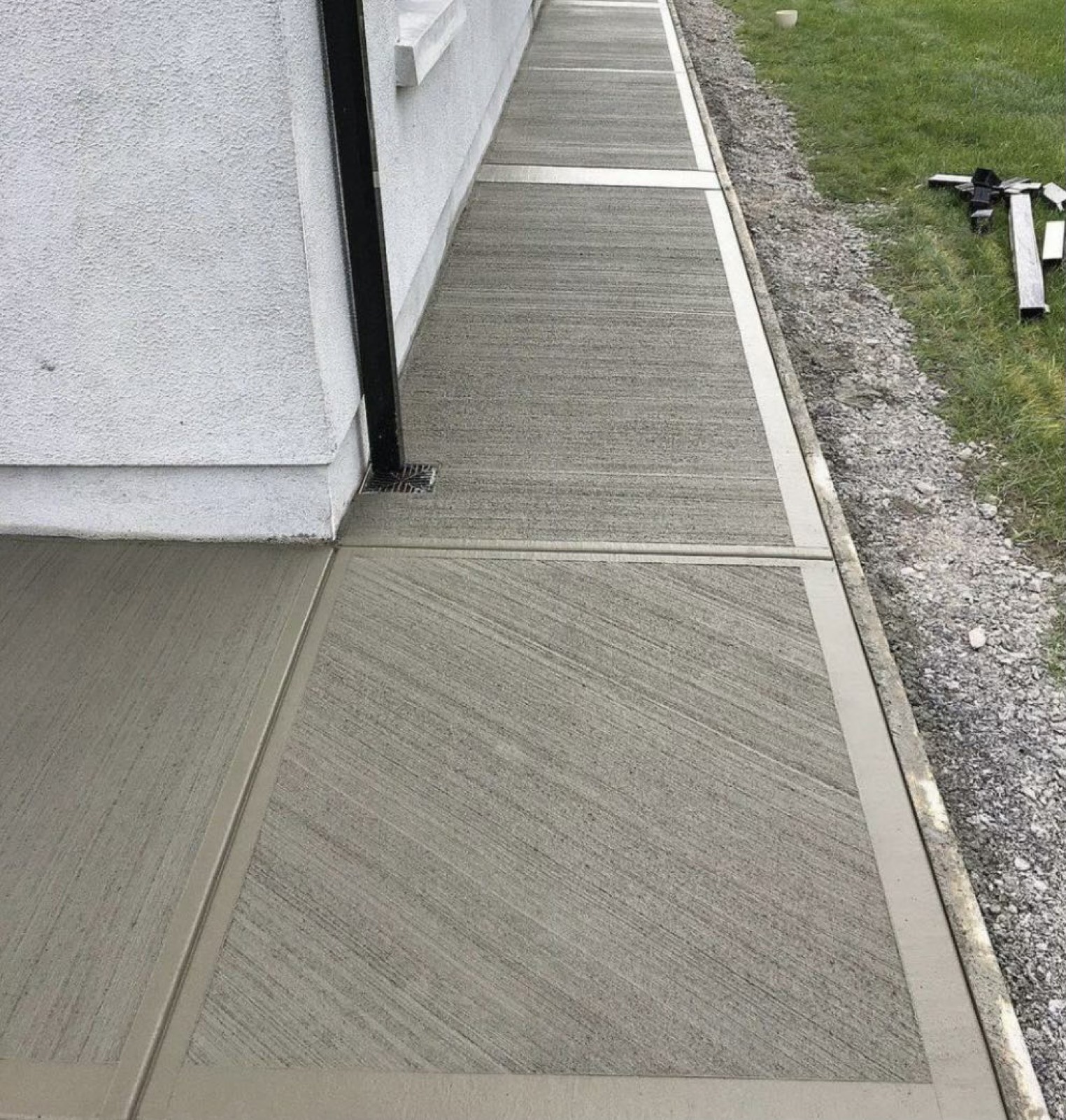 Long broom-finish concrete sidewalk along the side of a house